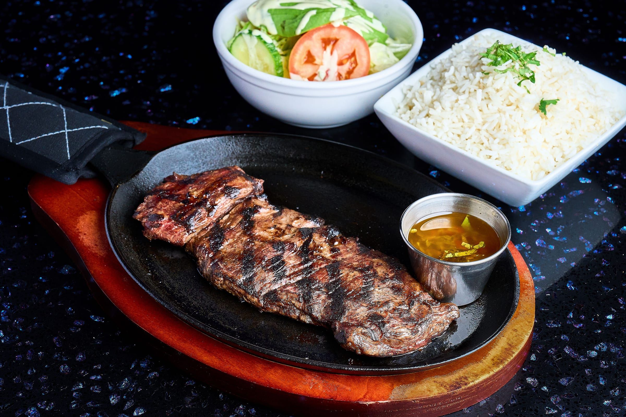 Grilled churrasco skirt steak on a sizzling plate